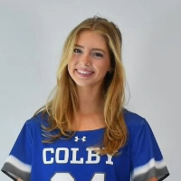 Smiling young woman in a blue sports jersey with COLBY and the number 21, posed against a light background.